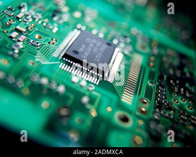 Circuit board. Circuit boards (green) connect electrical components to form a circuit. The components plug into the board at connection points (gold) Stock Photo