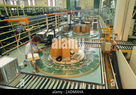 Circuit board manufacture. Workers constructing printed circuit boards on a factory production line. Stock Photo