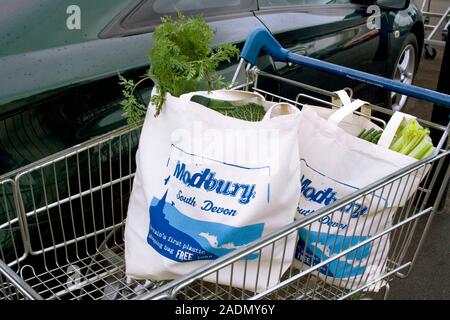 Modbury reusable shopping bags in a shopping trolley. Modbury, in South Devon, UK, was the first town in Europe to impose a complete ban on plastic ba Stock Photo