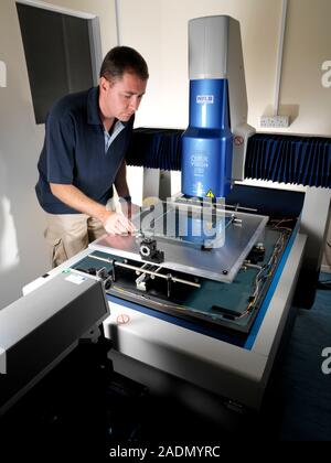 Circuit board quality control calibrator. Physicist adjusting a calibrating machine that uses an X-Y (two-dimensional) optical position standard. The Stock Photo