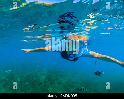Portrait of female in wetsuit apnea at Seychelles, Indian Ocean. Travel lifestyle watersport activity. Young caucasian woman snorkeling in tropical