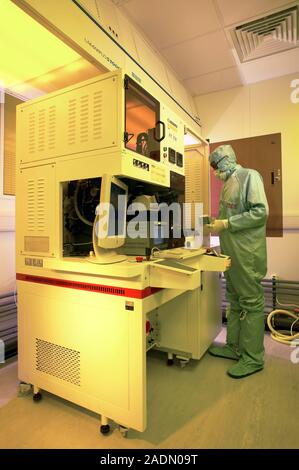 MODEL RELEASED. MEMS production. Clean room technician using flip chip bonding to mount MEMS (microelectromechanical systems) devices. MEMS devices ar Stock Photo
