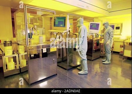 MODEL RELEASED. MEMS production. Clean room technicians using photolithography processes to produce MEMS (microelectromechanical systems) devices. MEM Stock Photo