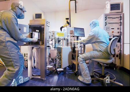 MODEL RELEASED. MEMS production. Clean room technicians using plasma etching techniques to produce MEMS (microelectromechanical systems) devices. MEMS Stock Photo