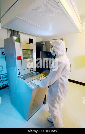 MODEL RELEASED. MEMS production. Clean room technician using a photolithography machine to produce MEMS (microelectromechanical systems) devices. MEMS Stock Photo