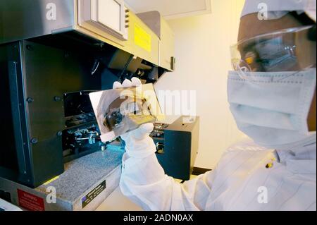 MODEL RELEASED. MEMS production. Clean room technician using a photolithography machine to produce MEMS (microelectromechanical systems) devices. MEMS Stock Photo