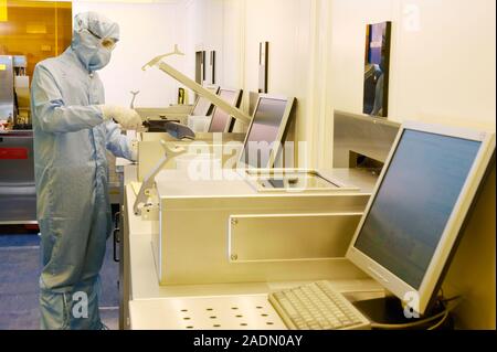 MODEL RELEASED. MEMS production. Clean room technician using a plasma etching machine to produce MEMS (microelectromechanical systems) devices. MEMS d Stock Photo