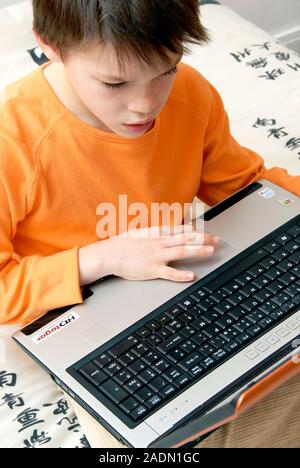 MODEL RELEASED. Boy using a laptop computer. Stock Photo