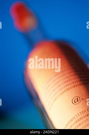 Message in a bottle. Conceptual image of a piece of paper printed with binary code and an at symbol in a bottle, representing e-mail. Stock Photo
