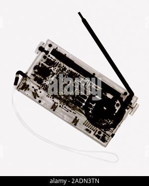 Radio. Coloured X-ray of a radio showing its electronic components. Radio waves transmitted from a radio station are received through the radio's aeri Stock Photo