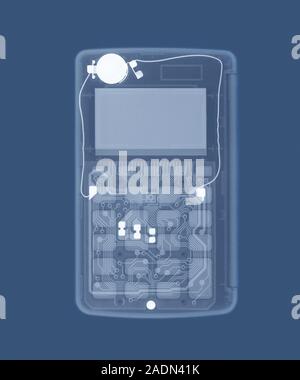 Calculator, coloured X-ray. The battery (white circle) is at upper left. The keypad is at lower centre, seen over the wiring of the circuit board. The Stock Photo