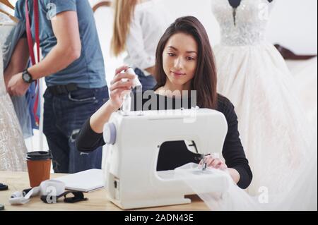 Hands of fashion designer doing embroidery on fabric with thread at  workshop stock photo