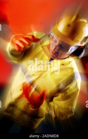 MODEL RELEASED. Protective clothing. Man wearing a hard hat, ear defenders, safety goggles, gloves and a high visibility jacket. Stock Photo