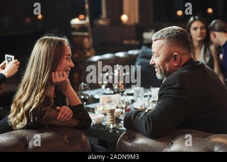 Interesting and funny conversation. Family friends having nice time in beautiful luxury modern restaurant Stock Photo
