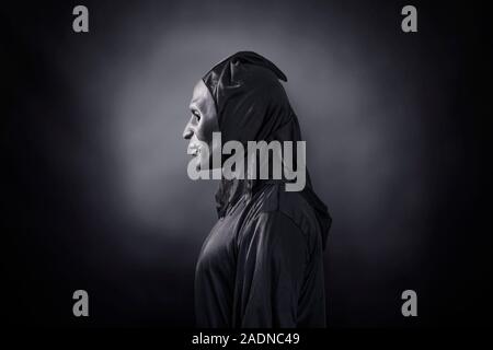 Scary figure with black mask in hooded cloak Stock Photo - Alamy