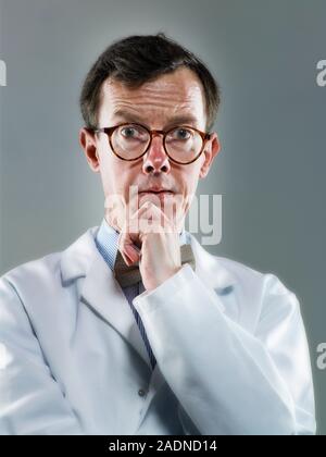 Chemist in a white coat looking thoughtful. Stock Photo