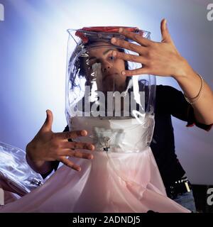 Protective suit manufacture. Technician checking the seals on the head part of a Mururoa cooled radiation protection suit. The suit provides protectio Stock Photo
