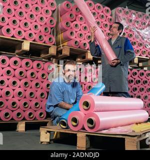 Protective suit manufacture. Technicians with rolls of PVC plastic used in the manufacture of Mururoa protective suits. The Mururoa suit is designed t Stock Photo