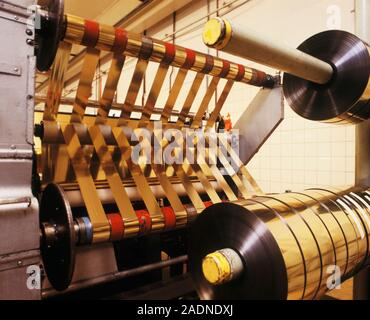 Gold foil production. Rolls of gold foil being produced at a factory. Gold foil is used inside high-quality headphones, and is also used to provide sh Stock Photo
