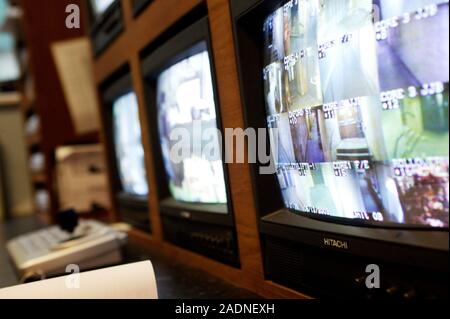 Security surveillance. Bank of surveillance monitors transmitting images from closed-circuit television (CCTV) cameras in a shopping area in London, E Stock Photo
