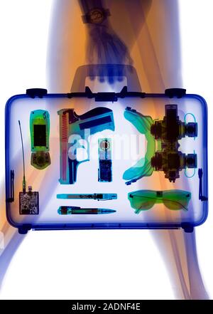 Handgun in briefcase. Coloured X-ray of a human carrying a briefcase containing a gun and other crime related items. Stock Photo