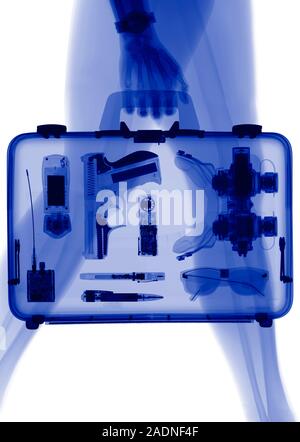 Handgun in briefcase. X-ray of a human carrying a briefcase containing a gun and other crime related items. Stock Photo