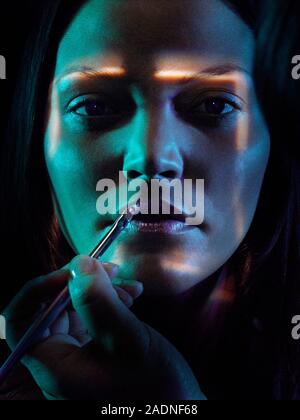 MODEL RELEASED. Face recognition and make-up application. Conceptual image of a biometric security system represented by a woman's face being scanned. Stock Photo