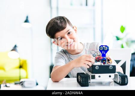 Joyful schoolboy involved in modern robotic engineering Stock Photo
