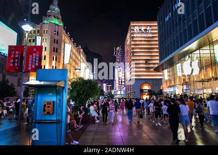 Shanghai, China - August 7, 2019: Nanjing road in downtown Shanghai with neon signs and shops and tourists walking around at night Stock Photo