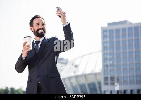 Joyful businessman making photos of urban setting Stock Photo