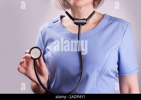 Closeup on a mature nurse holding stethoscope Stock Photo