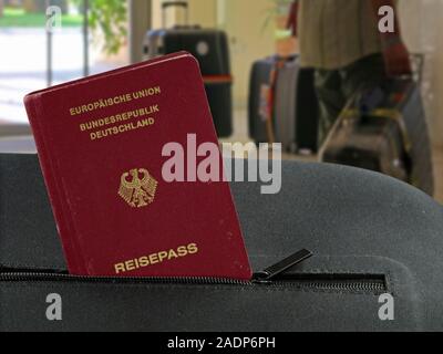 german passport in a pocket of a black suitcase with hotel lobby on background Stock Photo