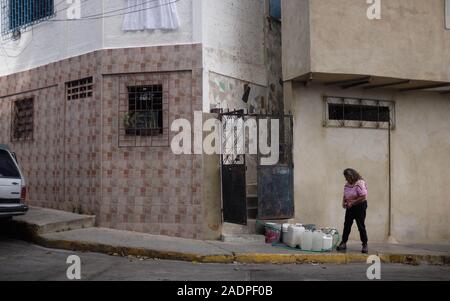 Caracas, Miranda, Venezuela. 29th Nov, 2019. Aura filling the water contaners with the water from her sister's house.Aura Graciela Sarmiento, age 56, and her husband Jose Alberto Abreu, age 62, have not had running water at their house in 4 years. Aura works in a store selling office furniture, and Jose is a mechanic. They live in the neighborhood of Altos de Lidice in Caracas Venezuela. Altos de Lidice is a historic Chavista neighborhood. However, Aura is pro-Opposition, and has never supported the Chavez regime even though she has lived in this pro-Chavez/Maduro barrio her whole life. S Stock Photo
