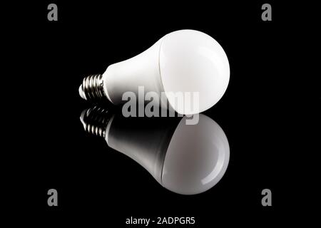 Energy saving light bulb on black table. LED light bulb. Stock Photo