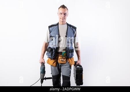 Builder with tools in a case, and a drill in his hand. Stock Photo