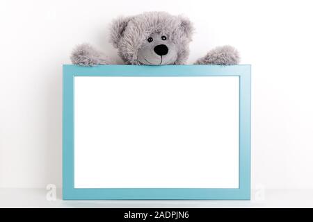Interior poster mock up for nurcery, children's room with vertical wooden frame and teddy bear on white wall background Stock Photo