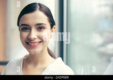 Pretty woman smiling to the camera while posing alone Stock Photo