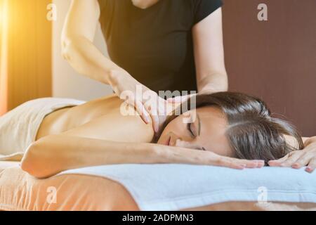 Adult mature woman resting on back massage procedure on massage table in beauty salon Stock Photo