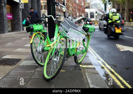 Two Lime-E cycles left on London street Stock Photo
