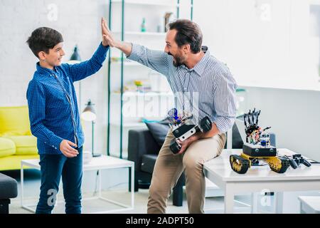 Overjoyed father and son giving high five Stock Photo