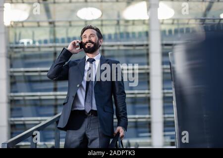 Low angle of a cheerful businessman talking on phone Stock Photo