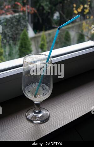 Empty coffee glass with a straw. Empty ice coffee glass. Stock Photo