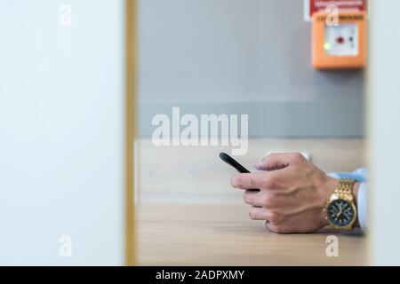 Businessman holding mobile phone in his hand trying to type a message. Stock Photo