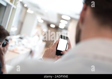 Businessman holding mobile phone in his hand trying to make a picture. Isolated cellphone screen. Stock Photo