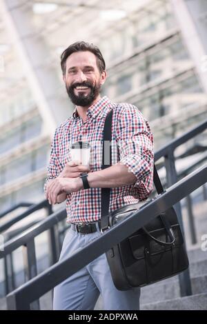 Optimistic adult man walking down the stairs outdoors Stock Photo