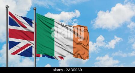 United Kingdom and Ireland flag waving in the wind against white cloudy blue sky together. Diplomacy concept, international relations. Stock Photo