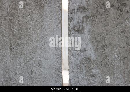cement wall with a peak through slit that lets the light through Stock Photo