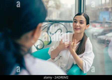 Emotional woman pointing to herself while talking Stock Photo