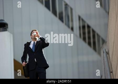 confident businessman striding Work with his morning coffee Stock Photo
