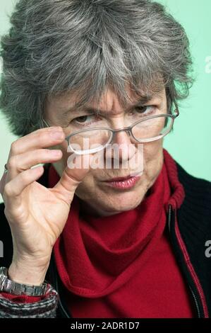 A portrait of a senior woman looking at the camera over her eyeglasses Stock Photo